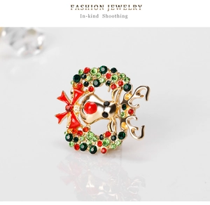 Détail de broche de Noël renne avec nœud rouge et strass colorés sur base dorée