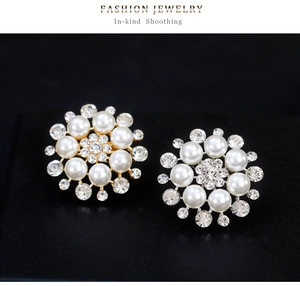 Detailed view of floral pearl and rhinestone stud earrings in gold and silver finishes