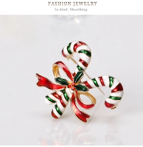 Makroaufnahme einer Weihnachts-Zuckerstangen-Brosche mit roter Schleife und Emaille
