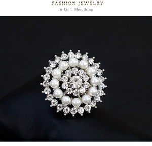 Détail macro d'une broche tournesol avec perles blanches et cristal brillant sur cuir noir