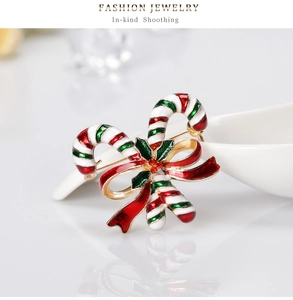 Detailaufnahme der Weihnachts-Brosche mit Zuckerstangen, roter Schleife und Stechpalme