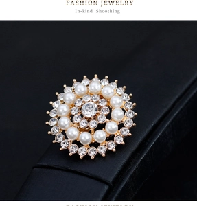 Détail d'une broche tournesol avec cristaux blancs et perles sur boîte en cuir