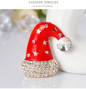 Detailed macro view of a Christmas hat brooch with red enamel and sparkling rhinestones