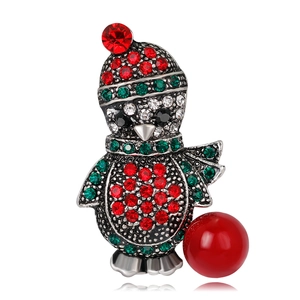 Detail view of penguin Christmas brooch with sparkling rhinestones and a red pearl