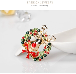 Macro de broche cerf de Noël avec strass colorés et un nœud rouge sur finition dorée