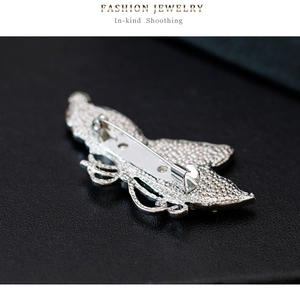 Detailed back view of silver butterfly brooch showing pin clasp and metallic texture