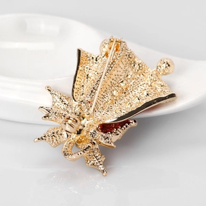 Vue arrière d'une broche cloche de Noël dorée avec fermoir épingle et finition texturée
