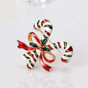 Weihnachts-Zuckerstangen-Brosche mit roter Schleife und Stechpalmenblättern auf Weiß