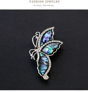Macro shot of butterfly brooch with natural abalone shell wings and inlaid cubic zirconia