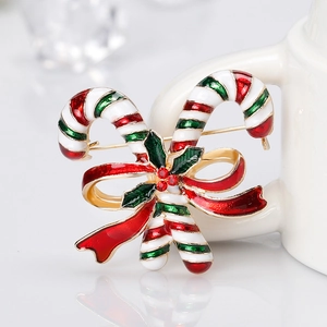 Weihnachts-Zuckerstangen-Brosche mit goldener Schleife auf weißem Keramikhintergrund
