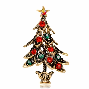 Detailed view of vintage gold Christmas tree brooch with festive red and green crystals