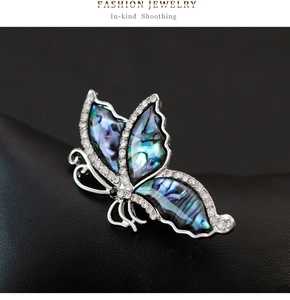 Macro detail of butterfly brooch with iridescent abalone shell and sparkling crystals