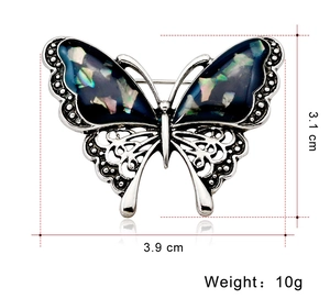 Detail view of butterfly brooch with shell inlay and dimensions 3.9cm by 3.1cm