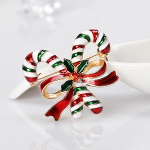 Weihnachts-Zuckerstangen-Brosche mit roter Schleife und Stechpalme auf weißem Grund