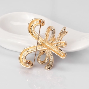 Rückansicht der goldenen Schleifen-Brosche mit Nadelverschluss und Hammerschlag-Struktur