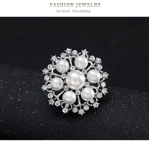 Détail macro d'une broche flocon de neige avec perle blanche et strass argentés