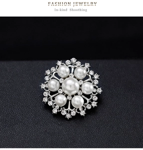 Macro d'une broche flocon en argent avec perles et strass brillants sur fond de cuir