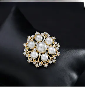 Détail d'une broche perle soleil élégante avec base dorée et cristaux brillants