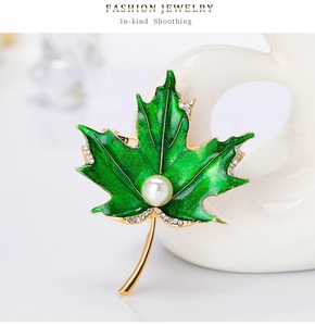 Détail de la broche feuille d'érable en émail vert avec perles et cristaux scintillants