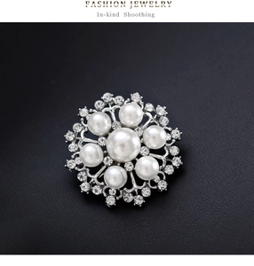 Gros plan détaillé d'une broche perle en forme de flocon avec strass sur cuir noir