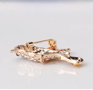 Macro shot of bird brooch back with golden plating, rhinestones and safety pin clasp