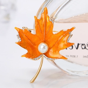Élégante broche feuille d'érable en émail orange et perles sur base en métal doré