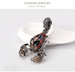 Close-up of vintage scorpion brooch featuring colorful rhinestones and retro silver finish