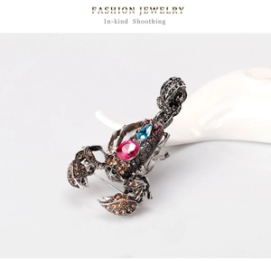 Macro detail of vintage scorpion brooch with pink rhinestones and silver alloy texture