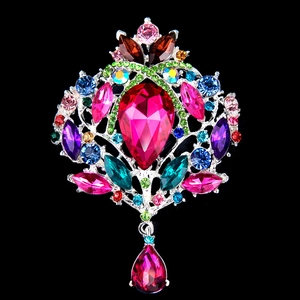 Exquisite silver-tone crown brooch featuring a large pink teardrop stone and colorful gems