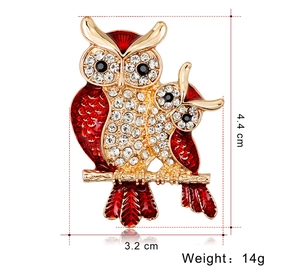 Detailed view of rhinestone owl brooch with red enamel wings, 4.4cm by 3.2cm size
