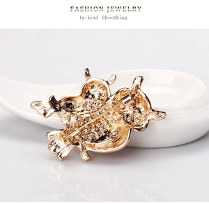 Detailed back view of gold owl brooch showing secure safety pin clasp and textured alloy finish