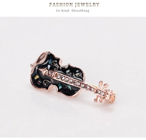 Détail de la broche violon avec finition or rose, émail noir et zircons incrustés