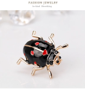 Detailed view of ladybug brooch with gold plating and red heart enamel patterns