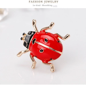Macro shot of fashion ladybug brooch with red enamel finish and gold plated details