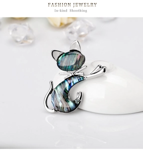Macro detail of a vintage cat brooch with iridescent shell inlay on silver metal frame