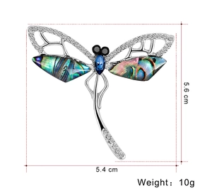 Detail of dragonfly brooch with abalone shell wings and blue crystal accents