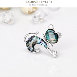 Detail of silver cat brooch featuring iridescent abalone shell inlay and elegant metal frame