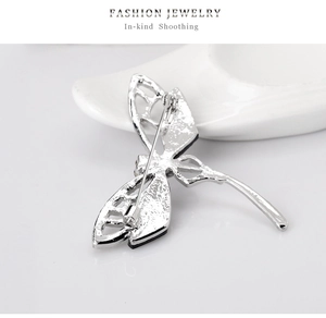 Detail view of the silver dragonfly brooch back showing the pin closure and metal texture