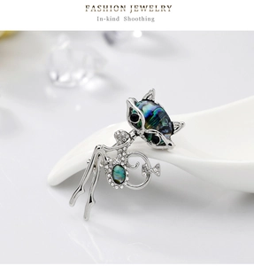 Détail d'une broche chat élégante ornée de cristaux scintillants et de nacre d'abalone