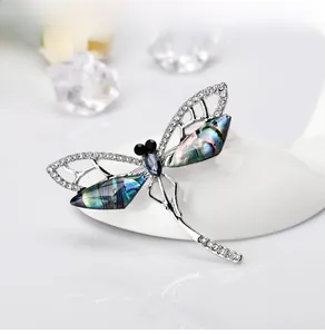 Close-up of vintage dragonfly brooch with iridescent shell wings and crystal details