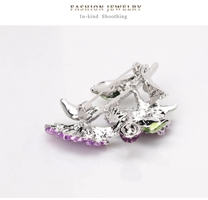 Dettaglio del retro della spilla a fiore in argento con chiusura a spilla e strass fini
