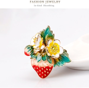 Détail d'une broche fraise et fleurs avec finition émail et strass jaune brillant