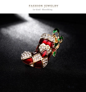 Gros plan détaillé d'une broche botte de Noël avec émail rouge et strass brillants