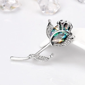 Élégante broche rose argentée avec centre en nacre d'abalone et strass brillants