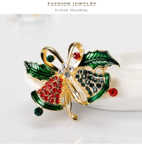 Close-up of a vintage gold Christmas bell brooch with red and green rhinestones