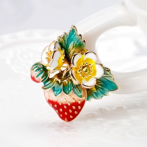 Broche fraise en émail chic avec fleurs et cristaux sur fond blanc impeccable