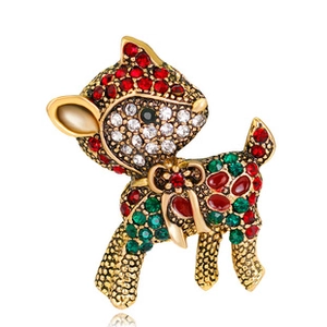 Macro detail of reindeer brooch with red and green rhinestones on gold plating