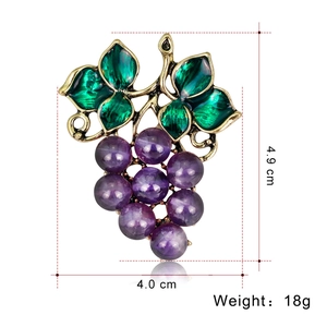 Spilla a uva viola vintage con foglie in smalto verde su sfondo bianco, misura 4.9cm x 4.0cm