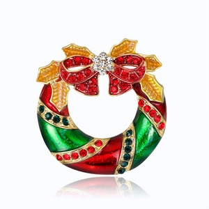 Detailed view of a Christmas wreath brooch with red bow and sparkling rhinestones