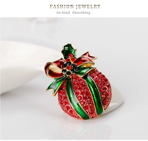 Detail of Christmas themed bell brooch with red rhinestones and green enamel bow